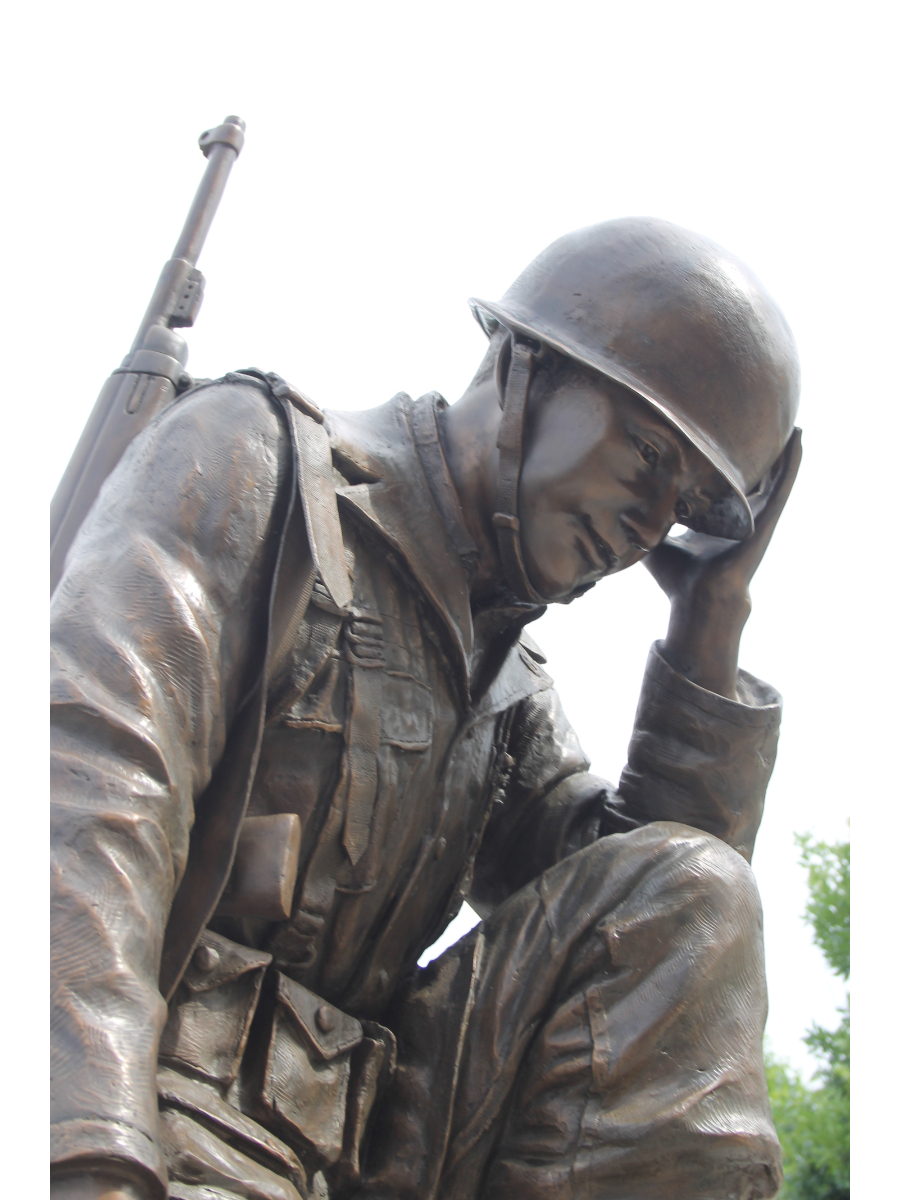 soldier kneeling at cross statue